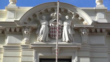 Monako Şehri, Monako - 4 Temmuz 2025 Prenslik armasını iki keşiş ve Adalet Sarayı cephesinde oyulmuş sloganla kapatın. Tercümesi: 