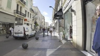 Cannes, Fransa - 10 Temmuz 2025: İnsanlar gün ışığında farklı dükkanların yakınında yürüyorlar