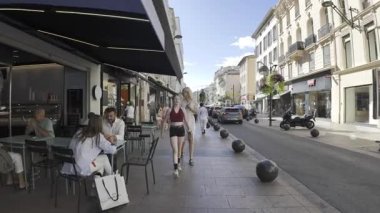 Cannes, Fransa - 10 Temmuz 2025: İnsanlar gün ışığında farklı dükkanların yakınında yürüyorlar