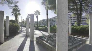 Cannes, Fransa - 11 Temmuz 2025: Fransız Rivierası 'nda kumlu bir halk plajına açılan avuç içi gölgeli gezinti alanı