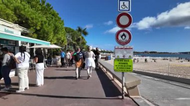 Cannes, Fransa - 12 Temmuz 2025: Güneşli bir günde deniz kenarında büfe gezen turistler
