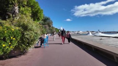 Cannes, Fransa - 12 Temmuz 2025: Güneşli bir günde insanlar deniz kenarında yürüyor
