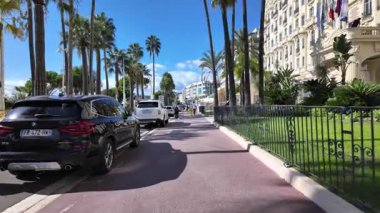 Cannes, Fransa - 12 Temmuz 2025: Güneşli bir günde insanlar deniz kenarında yürüyor