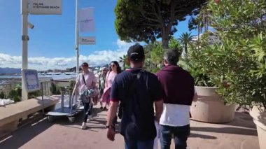 Cannes, Fransa - 12 Temmuz 2025: Güneşli bir günde insanlar deniz kenarında yürüyor