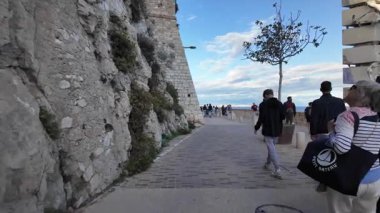 Antibes, Fransa - 14 Temmuz 2025: Sahildeki farklı binaların etrafında yürüyen insanların görüntüsü