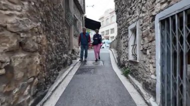 Antibes, Fransa - 14 Temmuz 2025: Bulutlu bir günde şehirdeki binalar arasındaki dar sokaklar