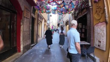 Güzel, Fransa - 16 Temmuz 2025: Güneşli bir günde insanlar şehrin sokaklarında yürüyor