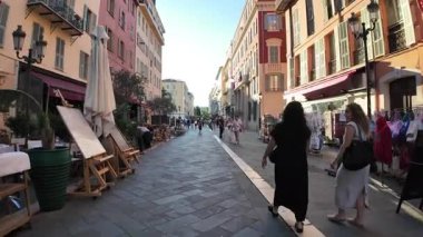 Güzel, Fransa - 16 Temmuz 2025: Güneşli bir günde insanlar şehrin sokaklarında yürüyor