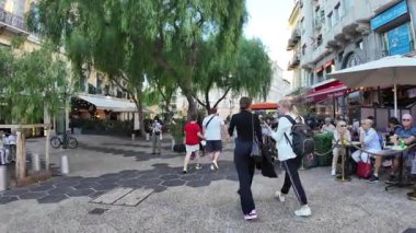 Güzel, Fransa - 16 Temmuz 2025: Güneşli bir günde insanlar şehrin sokaklarında yürüyor