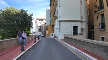 Monako Şehri, Monako - 18 Temmuz 2025: Rıhtımdaki yaya geçidi boyunca yürüyüş, güneşli bir günde şehrin dar ve büyüleyici bir caddesinde Akdeniz manzarasının tadını çıkarmak