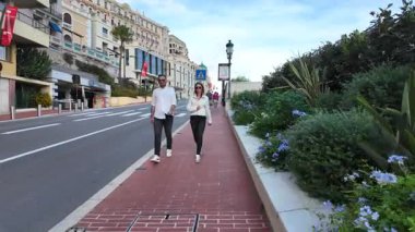 Monako Şehri, Monako - 18 Temmuz 2025: Turistler ve arabalar, güneşli bir günde Akdeniz manzarasının tadını çıkararak rıhtımdaki yayalar boyunca ilerliyorlar
