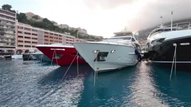 La Condamine, Monaco - 4 Temmuz 2025: Port Herkül 'e demirli lüks yatlar ve arka planda sisli tepeler