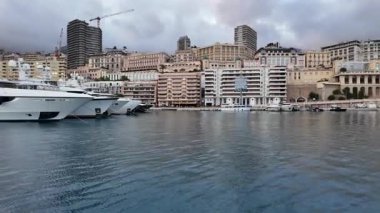 La Condamine, Monaco - 4 Temmuz 2025: Port Herkül 'e demirli lüks yatlar ve arka planda sisli tepeler