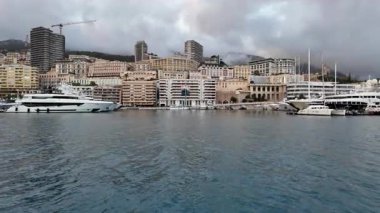 La Condamine, Monaco - 4 Temmuz 2025: Port Herkül 'e demirli lüks yatlar ve arka planda sisli tepeler