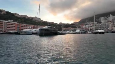 La Condamine, Monaco - 4 Temmuz 2025: Port Herkül 'e demirli lüks yatlar ve arka planda sisli tepeler