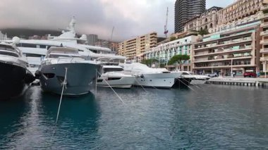 La Condamine, Monaco - 4 Temmuz 2025: Port Herkül 'e demirli lüks yatlar ve arka planda sisli tepeler