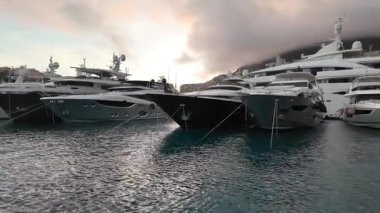 La Condamine, Monaco - 4 Temmuz 2025: Port Herkül 'e demirli lüks yatlar ve arka planda sisli tepeler