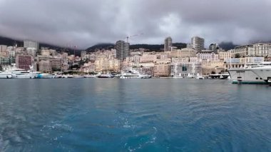 La Condamine, Monaco - 4 Temmuz 2025: Port Herkül 'e demirli lüks yatlar ve arka planda sisli tepeler