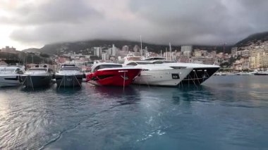 La Condamine, Monaco - 4 Temmuz 2025: Port Herkül 'e demirli lüks yatlar ve arka planda sisli tepeler