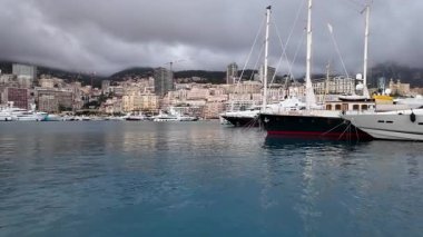 La Condamine, Monaco - 4 Temmuz 2025: Port Herkül 'e demirli lüks yatlar ve arka planda sisli tepeler