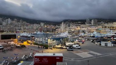 La Condamine, Monaco - 18 Temmuz 2025: Gri bulutlar altında yoğun yamaçlardaki dairelere karşı dolu yat limanı