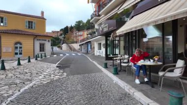 Villefranche-sur-Mer, Fransa - 18 Temmuz 2025: Pastel binalar arasında gün ışığında dar bir sokakta yürüyüş