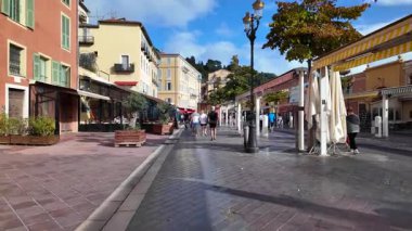 Güzel, Fransa - 20 Temmuz 2025: Güneşli bir günde insanlar şehrin sokaklarında yürüyor