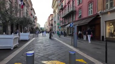 Güzel, Fransa - 20 Temmuz 2025: Güneşli bir günde insanlar şehrin sokaklarında yürüyor