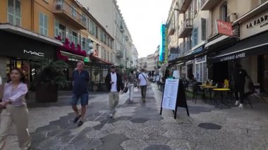 Güzel, Fransa - 20 Temmuz 2025: Güneşli bir günde insanlar şehrin sokaklarında yürüyor