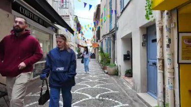 Antibes, Fransa - 20 Temmuz 2025: Bulutlu bir günde insanlar şehrin sokaklarında yürüyor