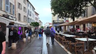 Antibes, Fransa - 20 Temmuz 2025: İnsanlar yağmur altında şehrin sokaklarında yürüyor