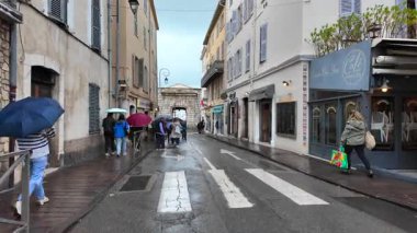 Antibes, Fransa - 20 Temmuz 2025: İnsanlar yağmur altında şehrin sokaklarında yürüyor