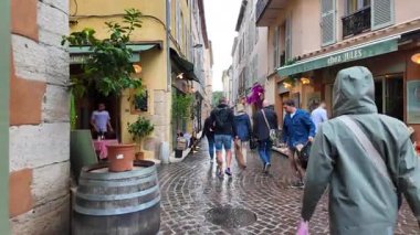 Antibes, Fransa - 20 Temmuz 2025: İnsanlar yağmur altında şehrin sokaklarında yürüyor