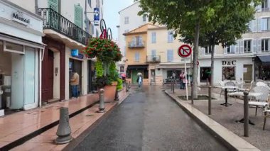 Antibes, Fransa - 20 Temmuz 2025: İnsanlar yağmur altında şehrin sokaklarında yürüyor