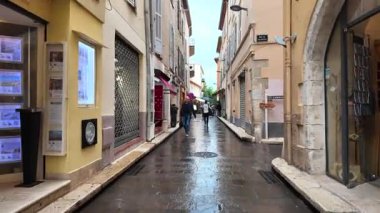 Antibes, Fransa - 20 Temmuz 2025: İnsanlar yağmur altında şehrin sokaklarında yürüyor