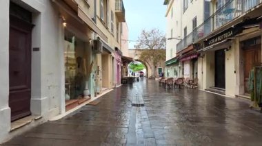 Antibes, Fransa - 20 Temmuz 2025: İnsanlar yağmur altında şehrin sokaklarında yürüyor