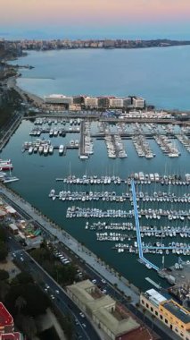 Alicante Limanı 'nın ve akşamları şehirdeki binaların insansız hava aracı görüntüsü. Dikey