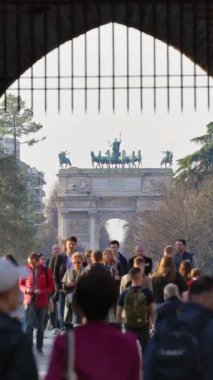 Milan, İtalya - 20 Mart 2025: Arka planda Barış Kemeri ile Sforzesco Kalesi 'ne gündüz vakti birden fazla kişi girip çıkıyor. Dikey