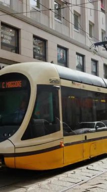 Milan, İtalya - 21 Mart 2025: Sarı tramvay gün ışığında şehrin sokaklarında hareket ediyor. Dikey