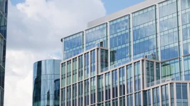 Londra 'nın finansal bölgesinin modern cam gökdelenleri tarihi mimarinin yanındaki mavi gökyüzünü yansıtıyor