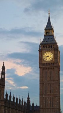 Big Ben 'in yakın çekim görüntüsü Londra, İngiltere' de alacakaranlıkta aydınlandı. Dikey
