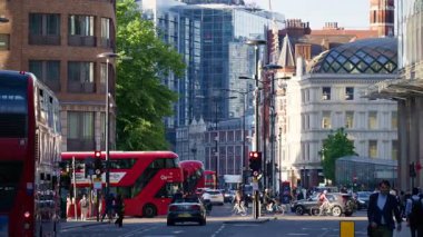Londra, İngiltere - 13 Mayıs 2025: Kalabalık Bishopsgate caddesini bisikletçiler ve yayalar gibi dolduran çok sayıda kırmızı çift katlı otobüs ve araba