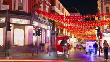 Londra, İngiltere - 14 Mayıs 2025: İnsanların ve arabaların akşam saatlerinde kırmızı fenerlerin altında Çin Kasabası 'nda hareket etmeleri