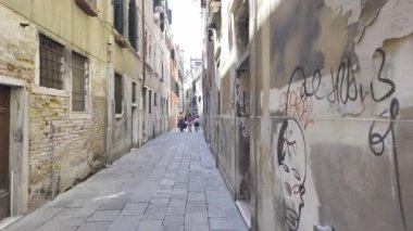 Venedik, İtalya - 9 Temmuz 2025: Dar bir caddeyi çevreleyen gondolları, köprüleri ve binaları olan bir kanal manzarası