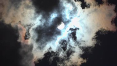 Güneşin alçak açılı görüntüsü gökyüzünde kara bir bulut aydınlatıyor.