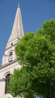 Londra 'nın merkezindeki St. Martin-in-the-Fields kilisesinin açık mavi gökyüzüne karşı ikonik beyaz kulesi. Dikey