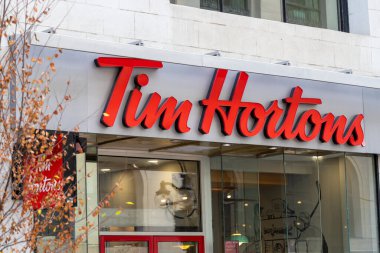 Ottawa, Canada - November 10, 2022: Signage of Tim Hortons fast food restaurant in downtown of the city in autumn. clipart