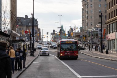 Ottawa, Kanada - 10 Kasım 2022: Şehir merkezindeki Rideau Caddesi 'ndeki otobüs. İnsanlar otobüs durağında toplu taşıma araçlarıyla yolculuk için bekliyorlar.