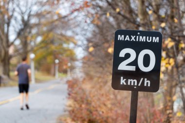 Hız limiti işareti, bisiklet şeritleri için saatte 20 kilometre. Park 'ta koşan adam.