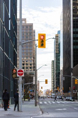 Ottawa, Kanada - 10 Kasım 2022: Şehir merkezinde gökyüzü ve ofis binalarına karşı trafik ışıkları. Şehrin iş bölgesinde gökdelenler. Gökdelenleri ve yürüyen insanları olan şehir manzarası.